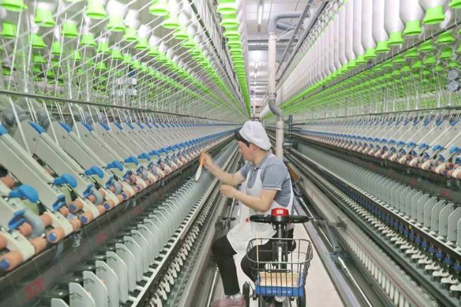 A woman works at a textile company in Nantong, east China's Jiangsu Province, Feb. 24, 2023. (Photo by Xu Congjun/Xinhua)