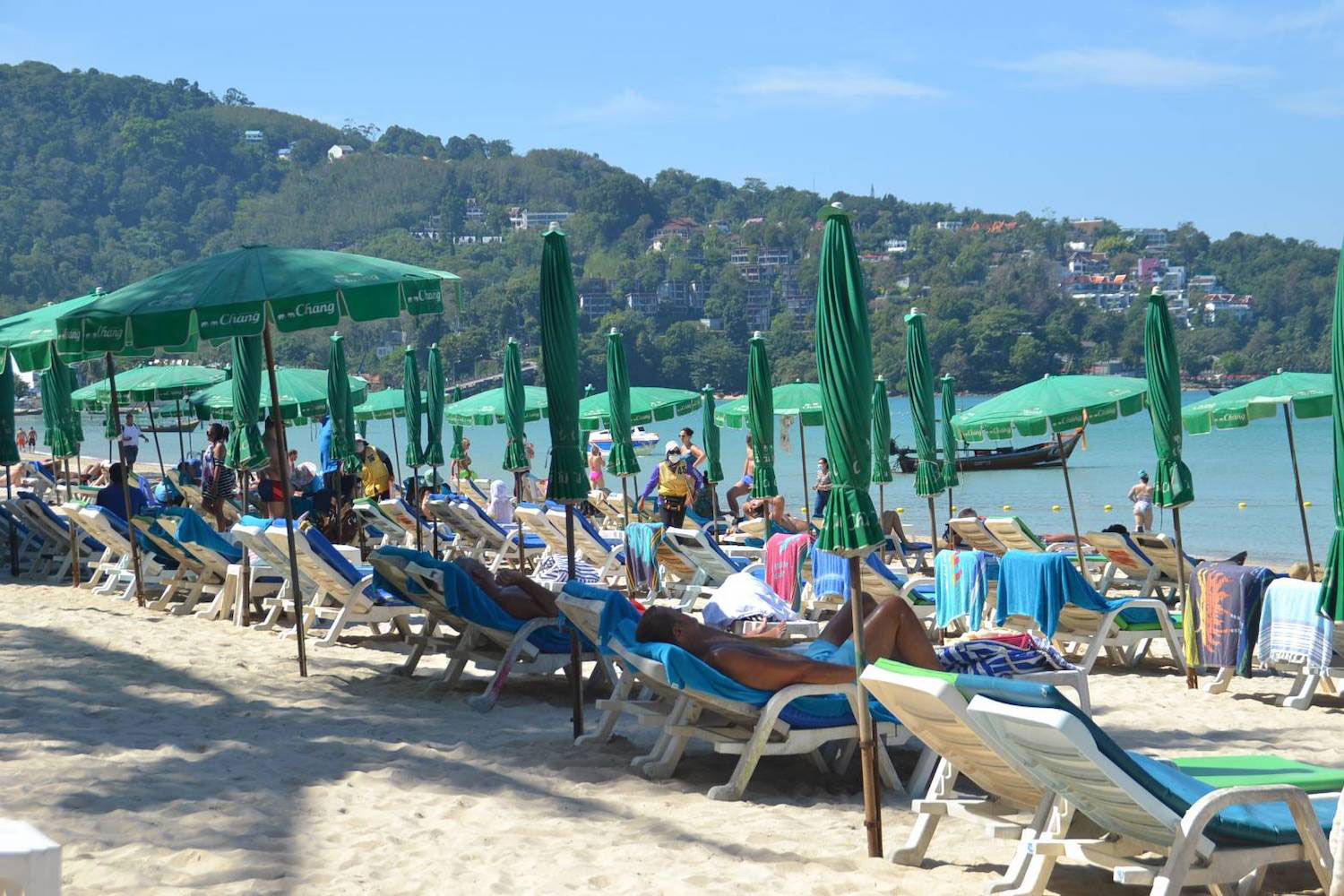 Tourists relax on a beach in Phuket province. (Photo: Achadthaya Chuenniran)