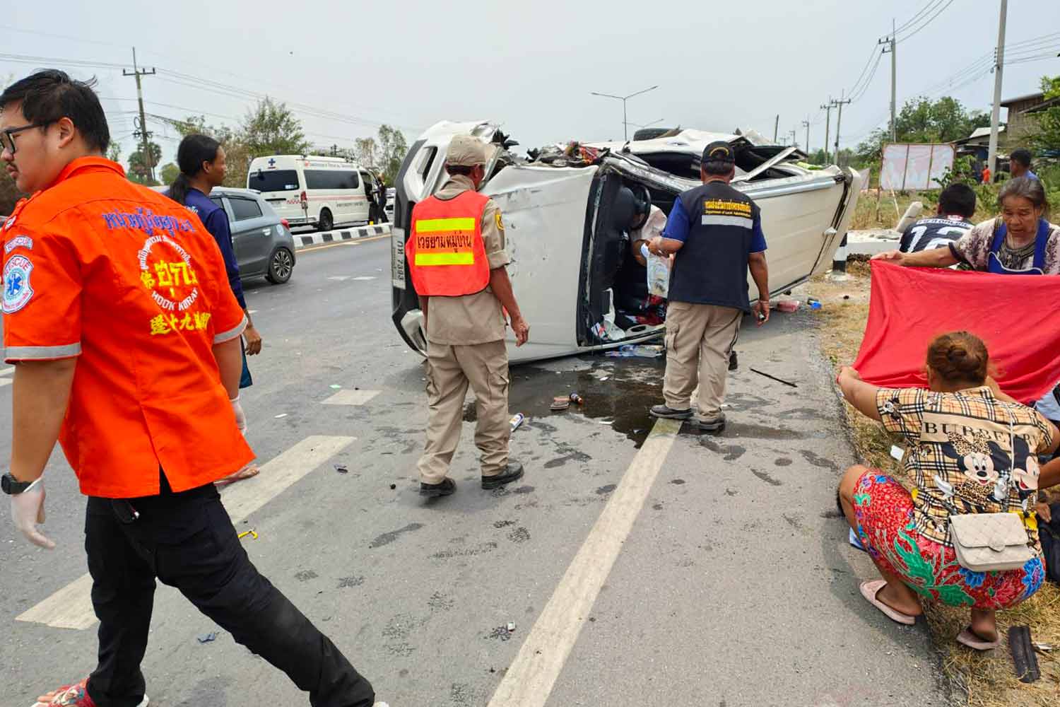 A capsized pickup truck rests on the Mitraparp Highway in Non Daeng district, Nakhon Ratchasima, after crashing into a power pole on Sunday. The two men in the truck were injured. (Photo: Prasit Tangprasert)