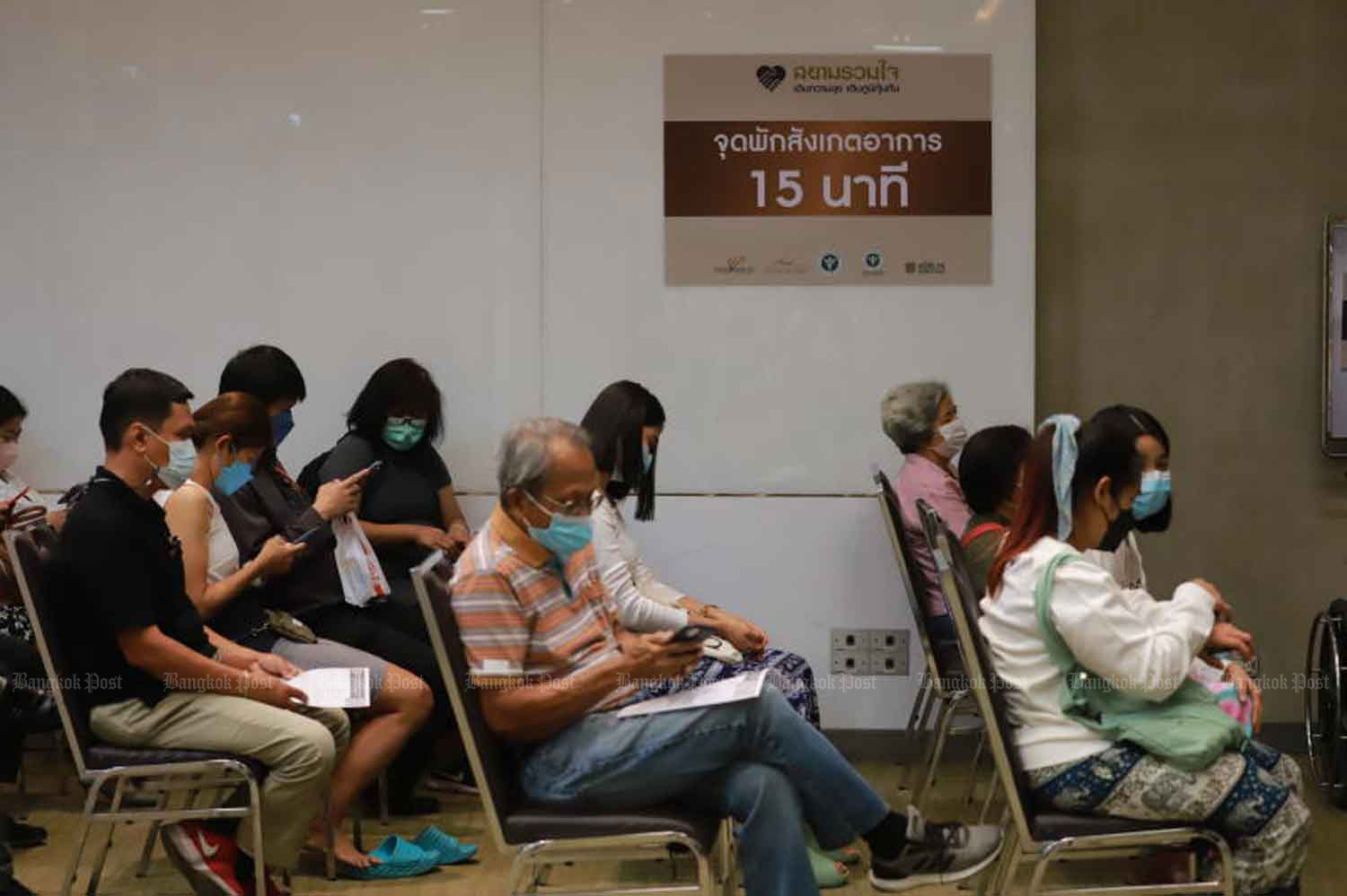 People wait during an observation period after receiving Covid-19 vaccines at a shopping centre in Bangkok in December 2022. (Photo: Somchai Poomlard)