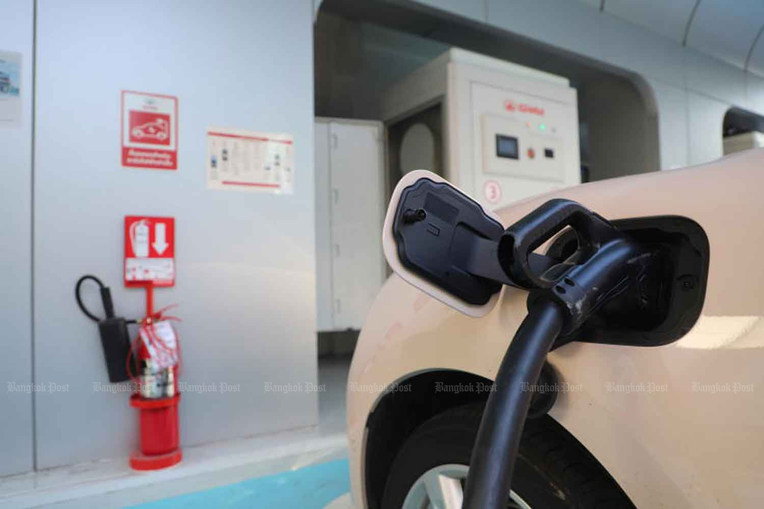 An electric vehicle is charged at an outlet in Bangkok. (Photo: Pornprom Satrabhaya)