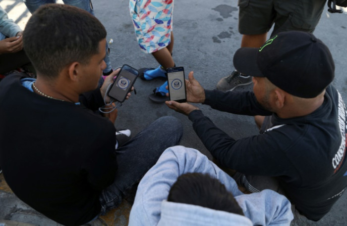 Migrants battle glitchy app at US border - Vimarsana News