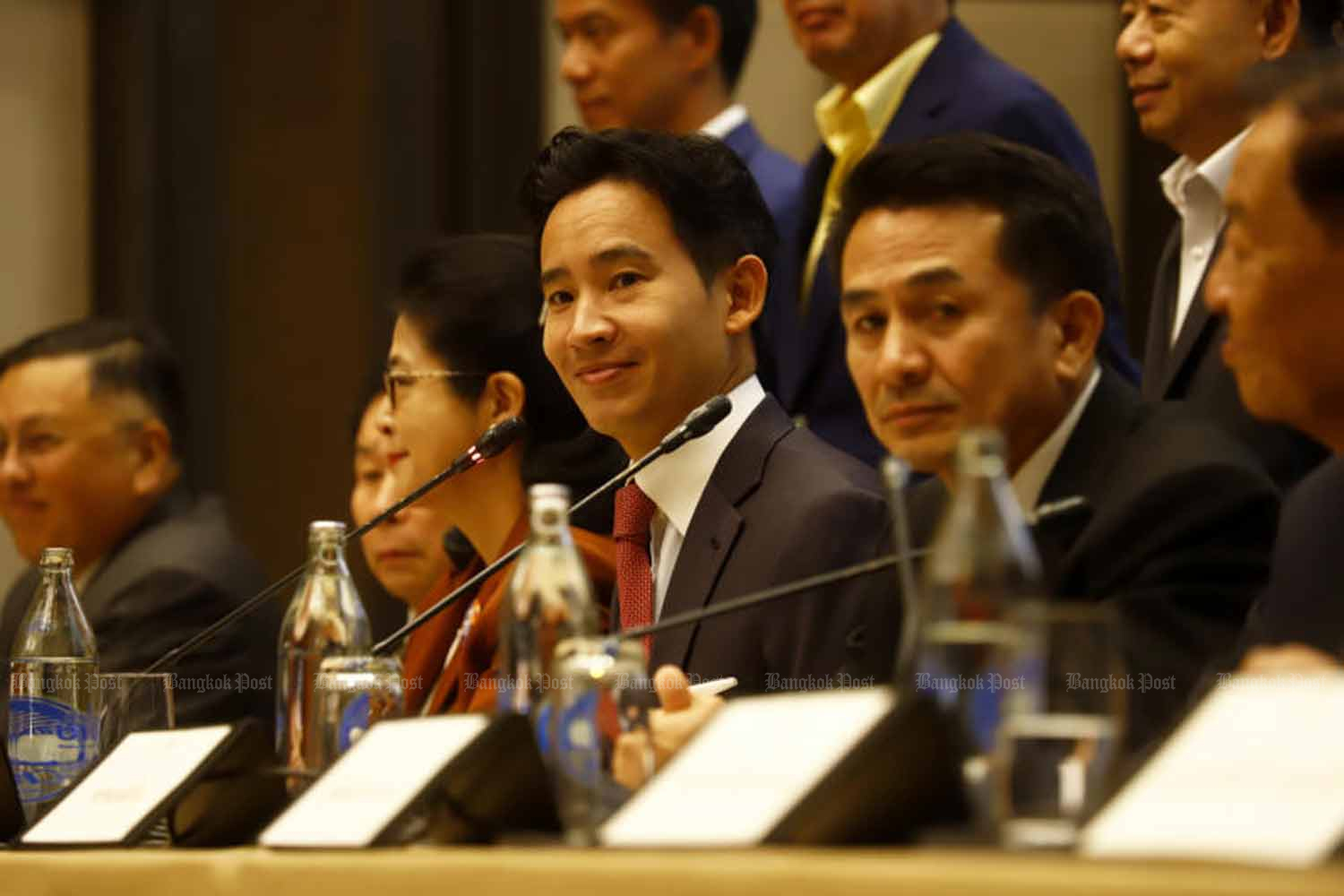 Move Forward Party leader Pita Limjaroenrat, centre, holds a press conference with leaders of seven other potential coalition parties to announce their agreement to form the new government on Thursday. On his left is Cholnan Srikaew, leader of the Pheu Thai Party. (Photo: Nutthawat Wicheanbut)