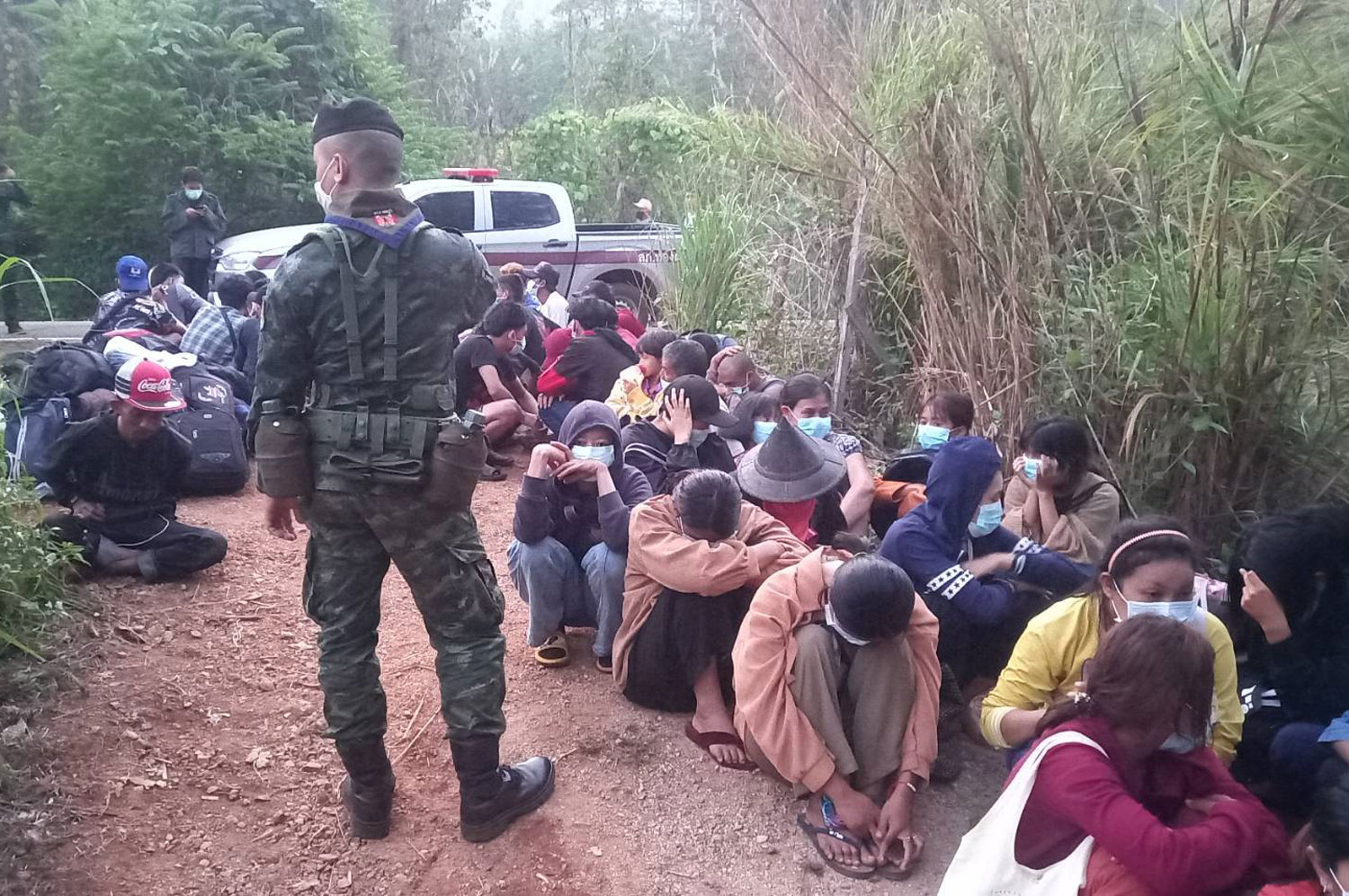 A soldier guards the 49 Myanmar nationals arrested for illegal entry in Thong Pha Phum district, Kanchanaburi, on Wednesday. (Photo: Piyarat Chongcharoen)