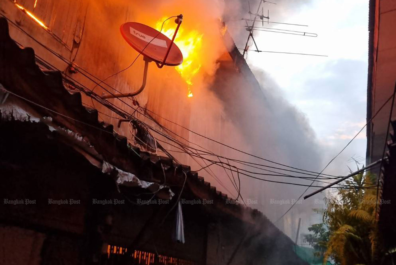 A fire rages through a community in Soi Wutthakat, Talat Phlu area of Thon Buri district, Bangkok, on Wednesday morning.  (Photo: FM91 Trafficpro)