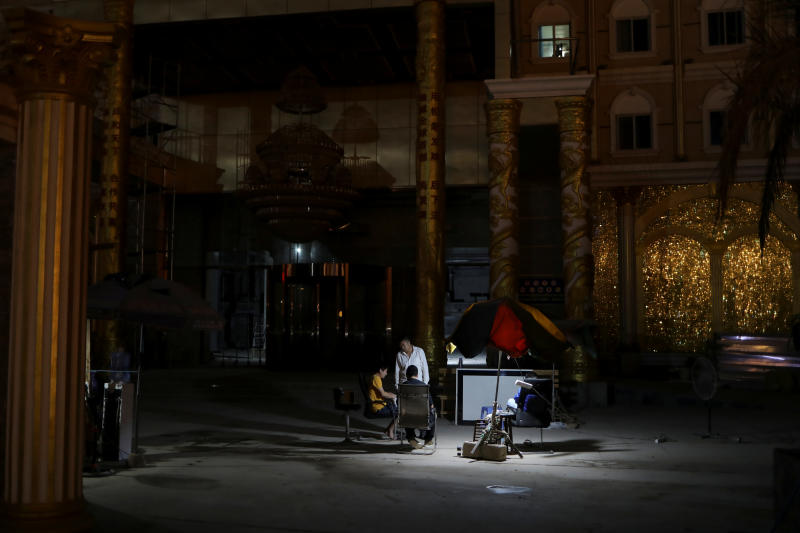 Men sit together outside a closed-down casino in Sihanoukville, Cambodia, on Feb 27, 2020. (Photo: Reuters)