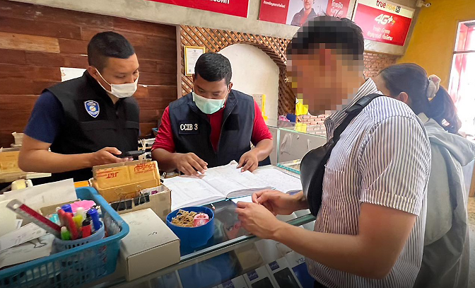 Officers check documents at a store selling illegal SIM cards in Nong Khai province on Saturday. (Photos: CCIB)