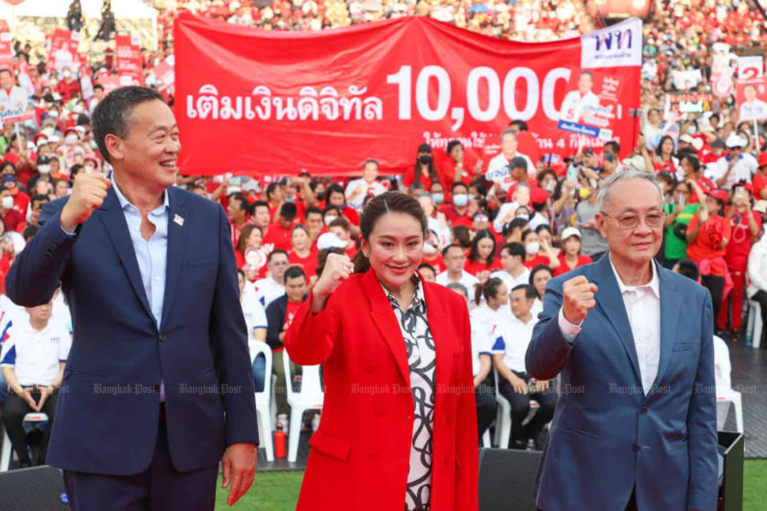 A large banner declars the Pheu Thai's policy of a 10,000-baht digital handout, at a rally to introduce the party's three candidates for prime minister on April 6. (Photo: Pattarapong Chatpattarasill)