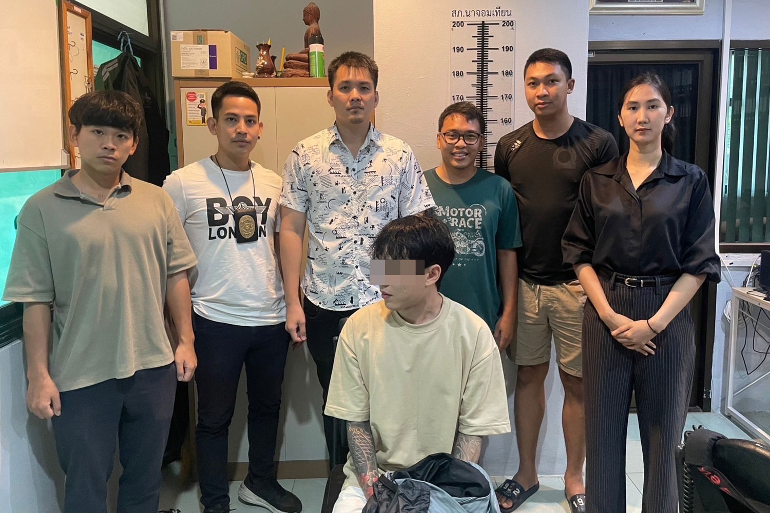 Officers keep watch on South Korean drug suspect Kim in Sattahip district of Chon Buri. (Photo supplied: Chaiyot Pupattanapong)