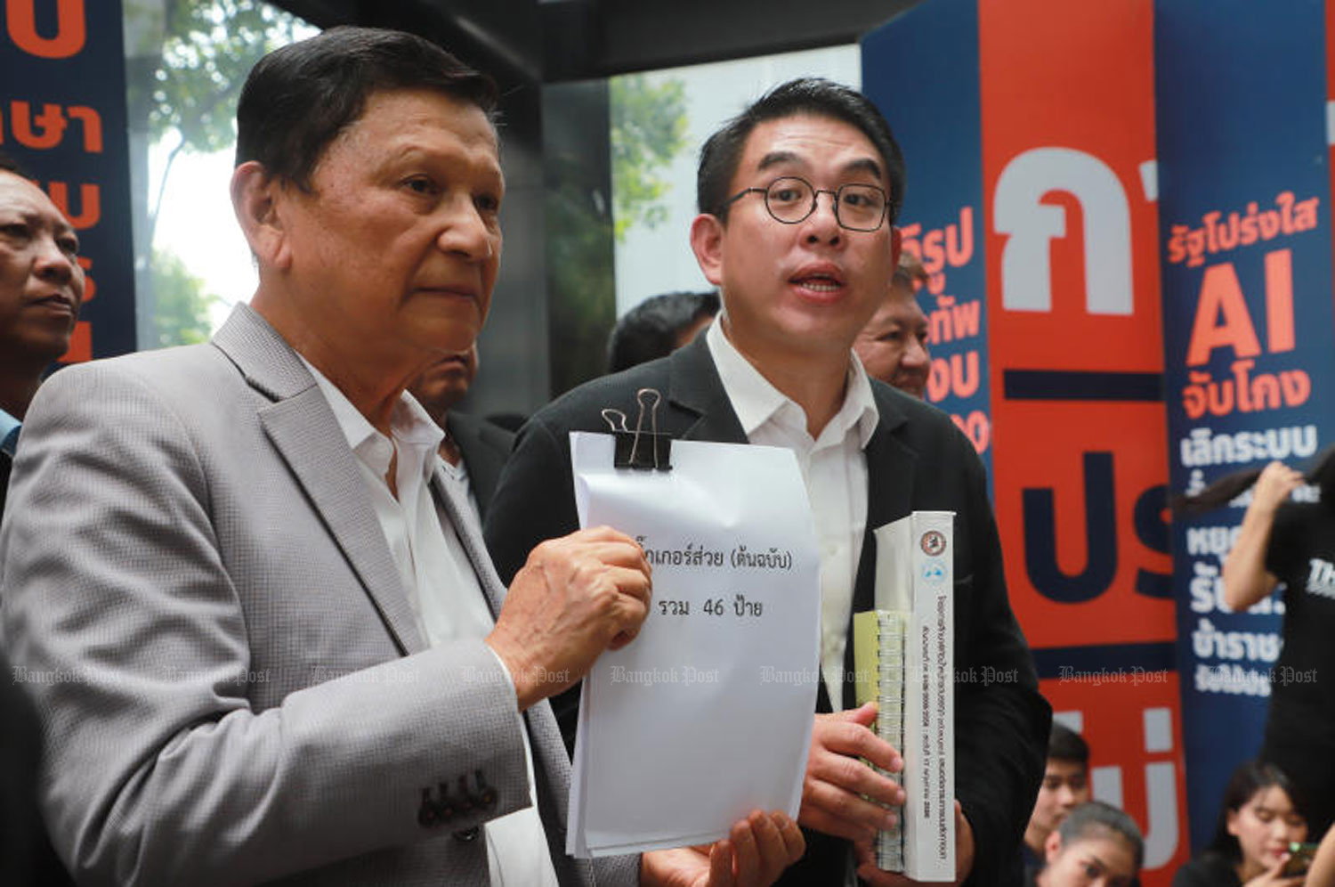 Apichart Prairungruang, left, head of the Land Transport Federation of Thailand, leads federation members in submitting information about truck bribery stickers to Wiroj Lakkhanaadisorn, a Move Forward Party list MP-elect campaigning against the bribery at the party’s HQ on 1 June. (Photo: Somchai Poomlard)