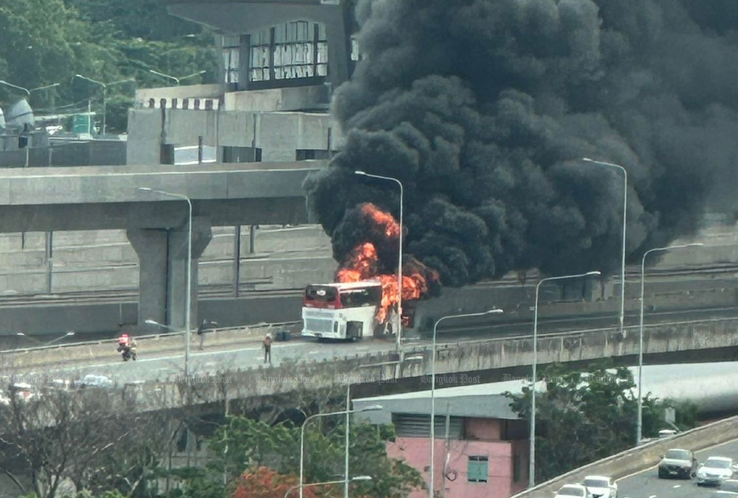 Smoke and flames billow from the burning tour bus on Si Rat Expressway, above Krungthep Aphiwat Central Terminal in Bangkok's Chatuchak district, on Wednesday morning. The 15 Polish tourists on board all escaped injury. (Photo: FM91 Trafficpro)