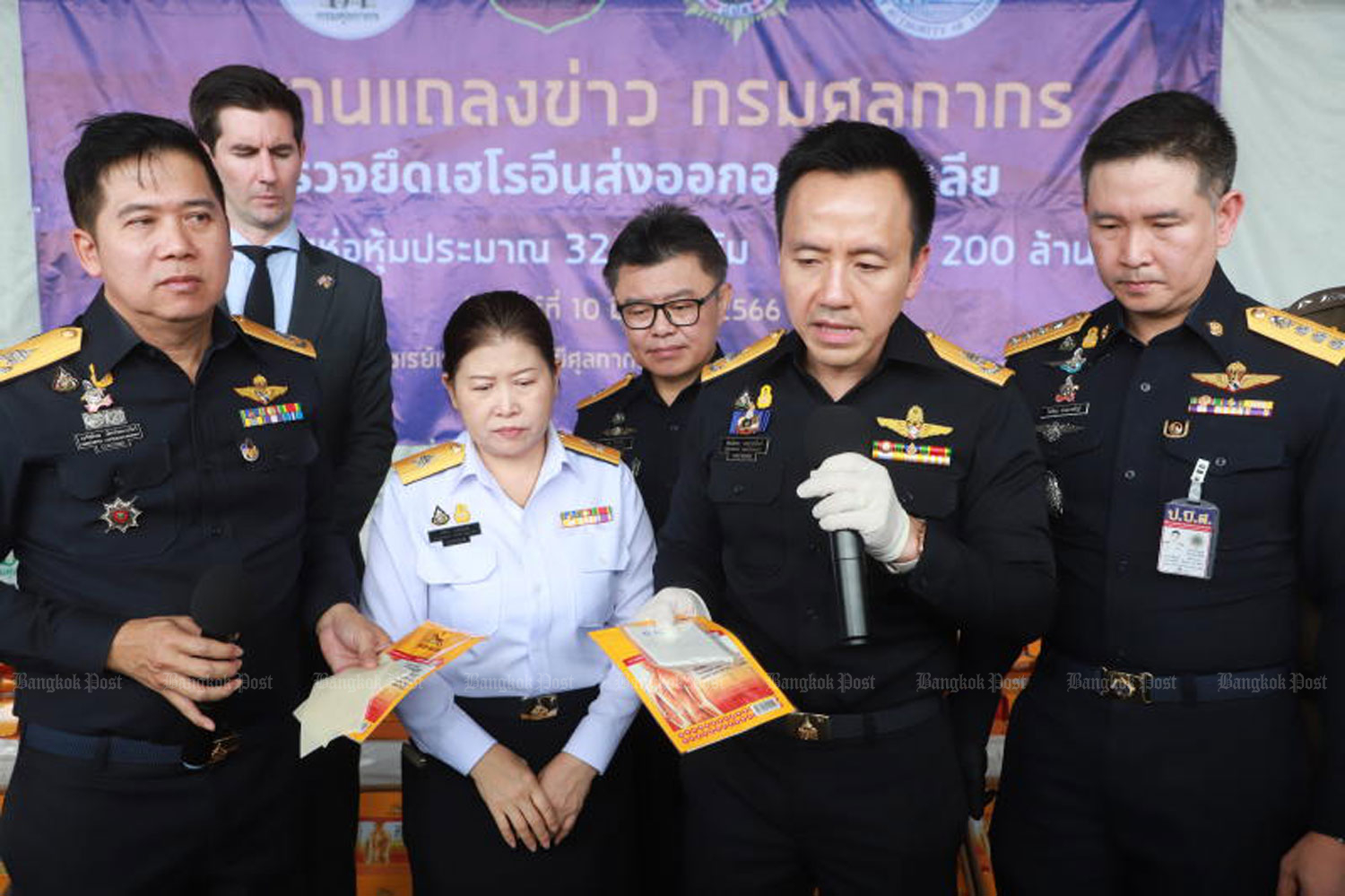 Phanthong Loykulnanta, deputy director-general of the Customs Department, displays a small plastic bag of heroin found inside a pack of commercial pain-relief patches at a briefing on Saturday. (Photo: Somchai Poomlard)