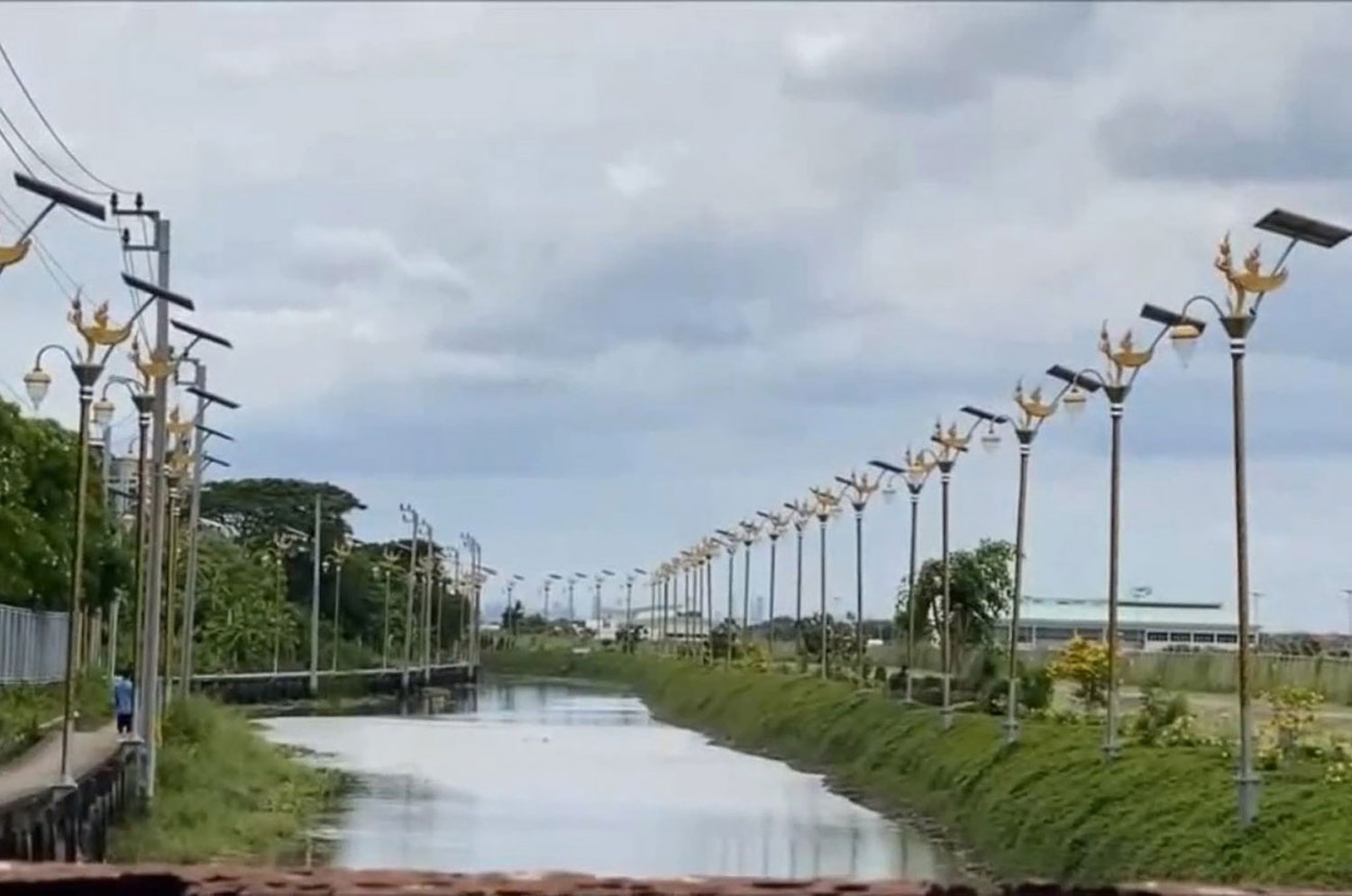 Closely spaced solar-powered lamp posts topped with mythical kinnaree figures line both sides of a flooded street in tambon Racha Thewa of Samut Prakan province in a photo taken in June 2021. (File photo: Sutthiwit Chayutworakan)