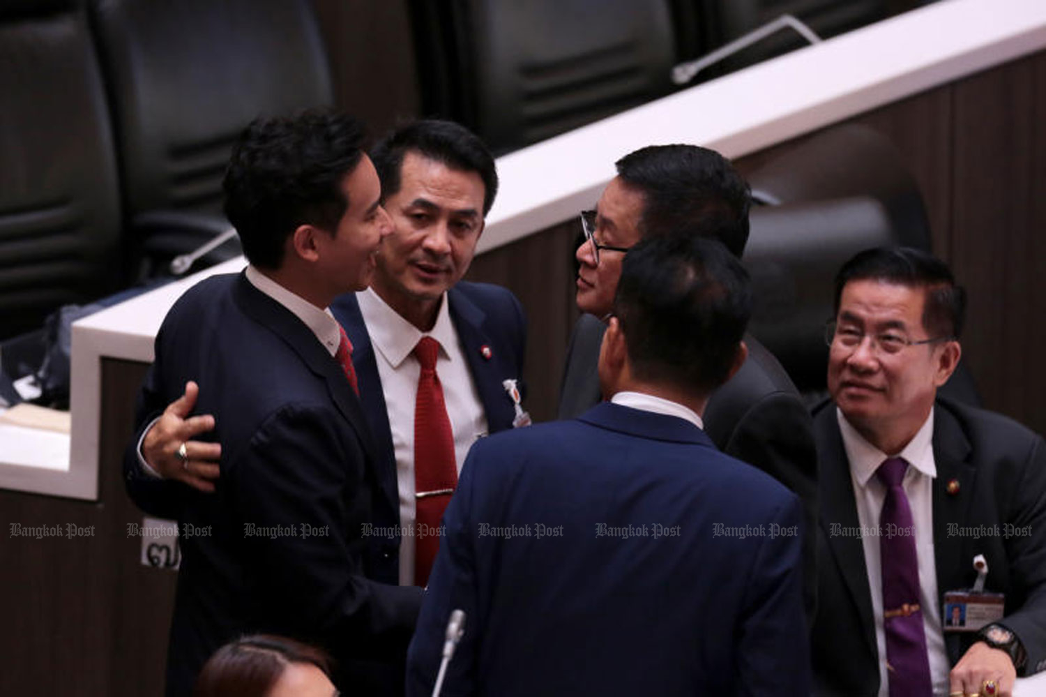 Pheu Thai Party leader Cholnan Srikaew, centre, touches Move Forward Party leader Pita Limjaroenrat, sole prime ministerial candidate, left, as Pheu Thai secretary-general Prasert Chantararuangthong, right, and other party members greet the MFP leader at the parliament before the House of Representatives and the Senate started their joint sitting for the prime ministerial vote on Thursday. (Photo: Chanat Katanyu)