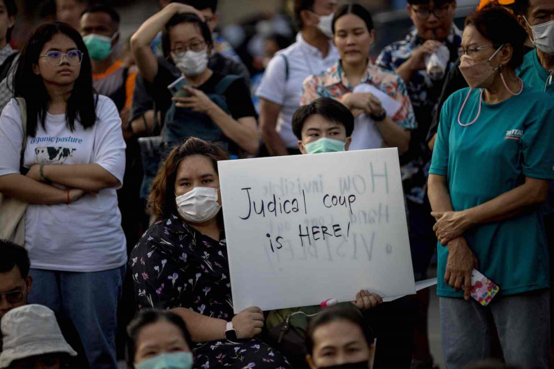 A protester holds up a placard during a protest at Democracy Monument on Wednesday evening following the court-ordered suspension of Move Forward Party leader and prime ministerial candidate Pita Limjaroenrat earlier in the day and a subsequent vote to prevent his nomination from being considered a second time. (Photo: AFP)
