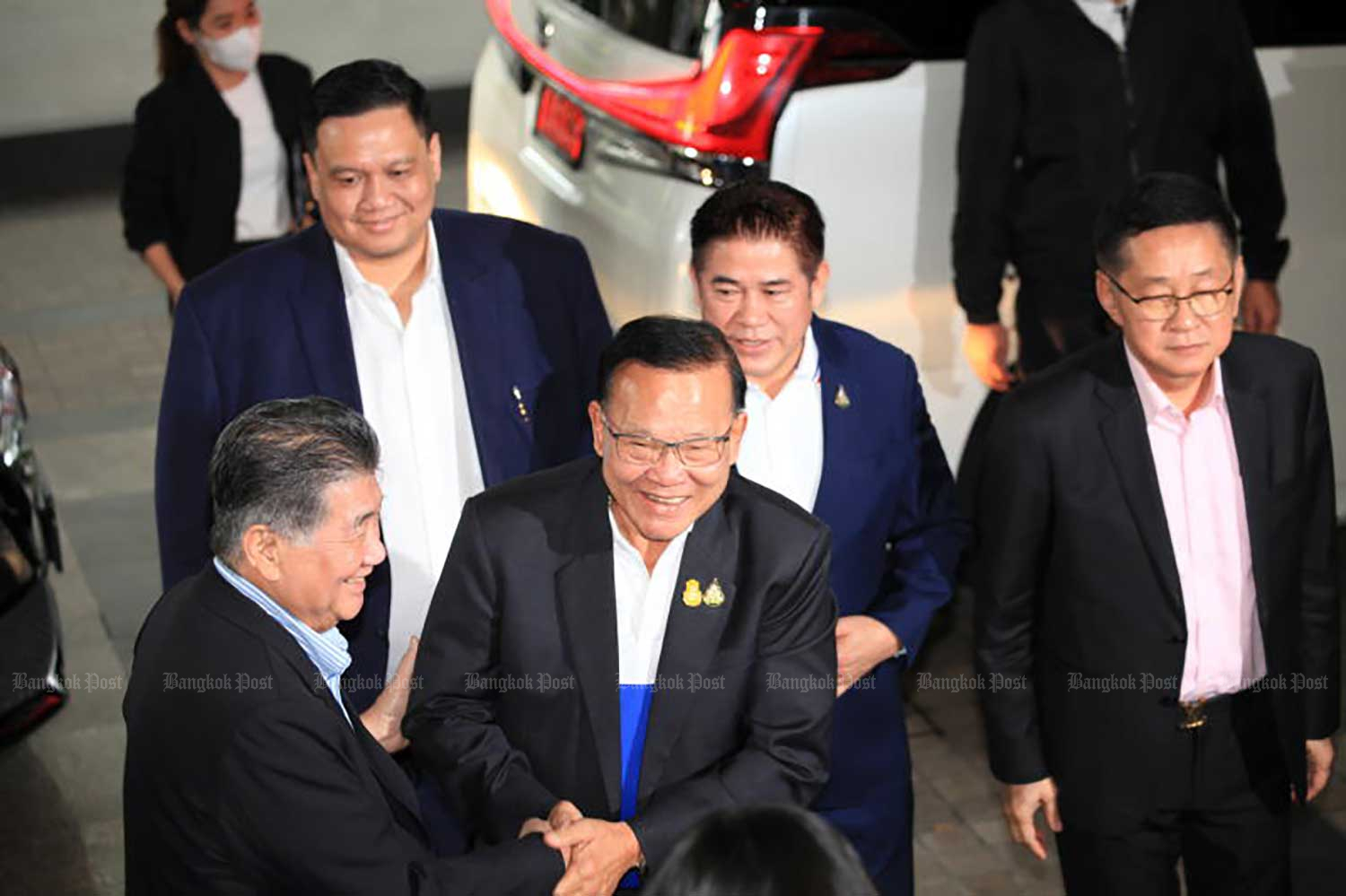 Pheu Thai Party deputy leader Phumtham Wechayachai, left, welcomes Santi Prompat, secretary-general of the Palang Pracharath Party (PPRP), and Thamanat Prompow, PPRP's MP coordinator, second from right, at the Pheu Thai Party headquarters on Sunday. (Photo: Apichart Jinakul)