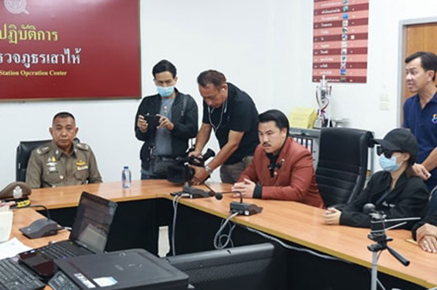 The woman, seated right, accompanied by social media advocate Kanthat Pongpaiboonvej, alias Kan Chompalang, files a complaint with police in Saraburi against a police lieutenant colonel she said demanded 100,000 baht from her and also asked to have sex in exchange for dropping a trespassing charge. (Photo: Kan Chompalang Facebook)