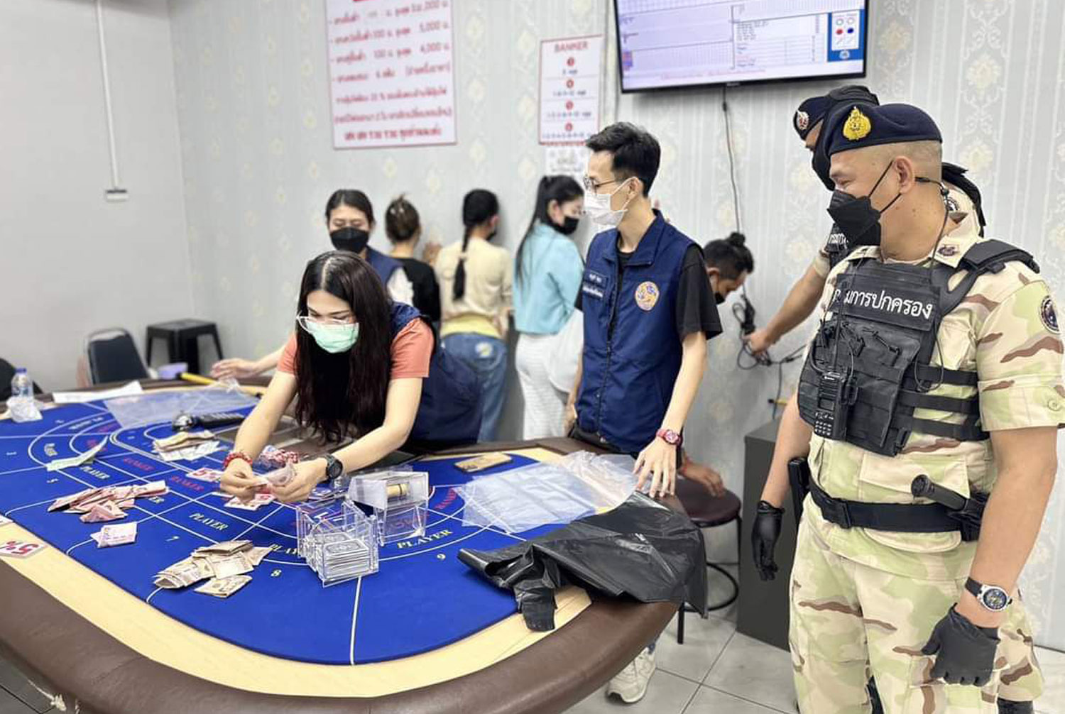 Officials seize cash, decks of gambling cards and other gambling paraphernalia during a raid on the 89 CLUB Casino in Muang district of Chiang Mai on Wednesday. Five senior police officers from Chang Phueak police station have been transferred to inactive posts following the raid. (Photo: Panumate Tanraksa)