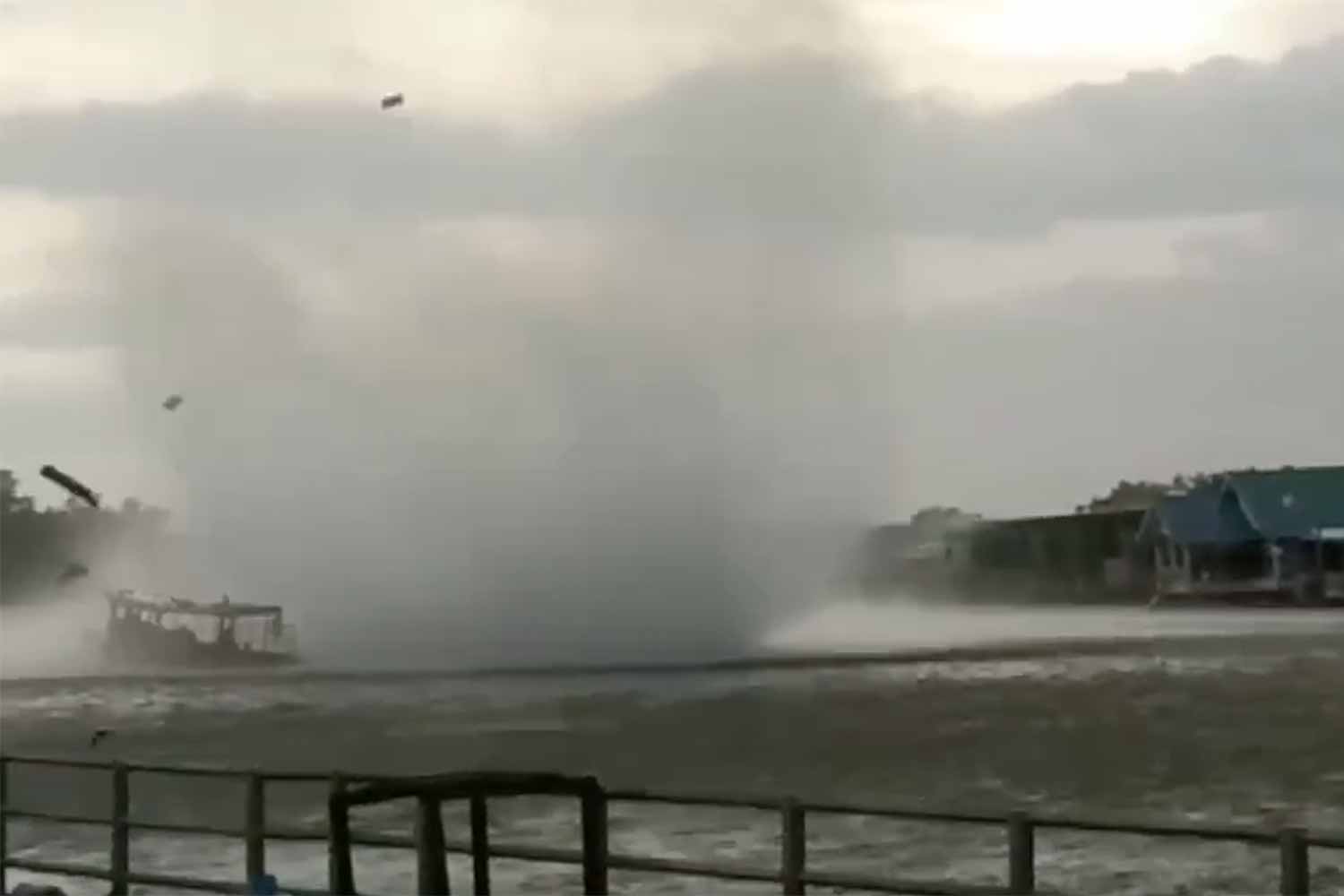 A video clip taken by a man dining with his family at a restaurant shows a tour boat, with seven tourists on board, being hit by a waterspout on Saturday afternoon.  (Screenshot)