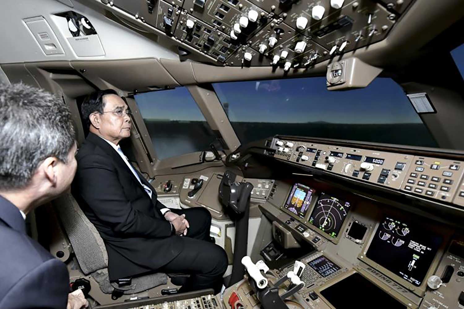 Prime Minister Prayut Chan-o-cha on Friday sits in a flight simulator cockpit at the Thai Airways International (THAI) headquarters on Vibnhavadi Rangsit Road during a visit to find out about THAI's speedy recovery and its current and future business plans. (Photo: Government House)