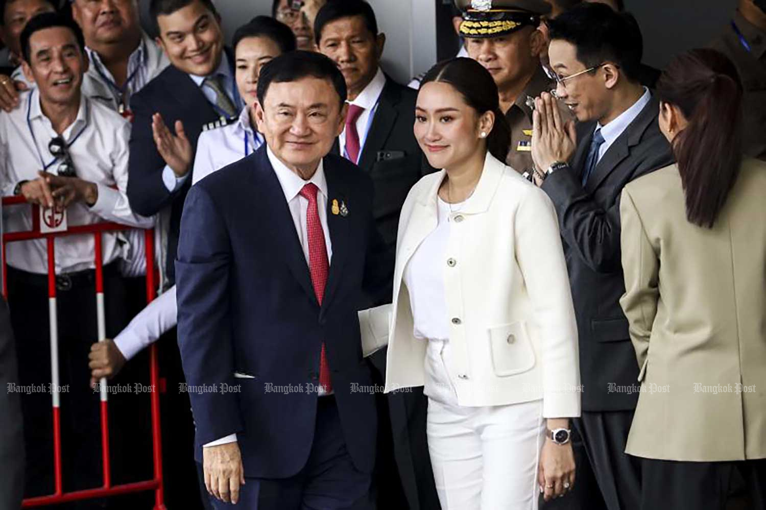 Former prime minister Thaksin Shinawatra, left, appears with his children briefly in front of the private jet terminal of Don Mueang airport when he returned to the country in the morning of on Aug 22. (Photo: Pattarapong Chatpattarasill)