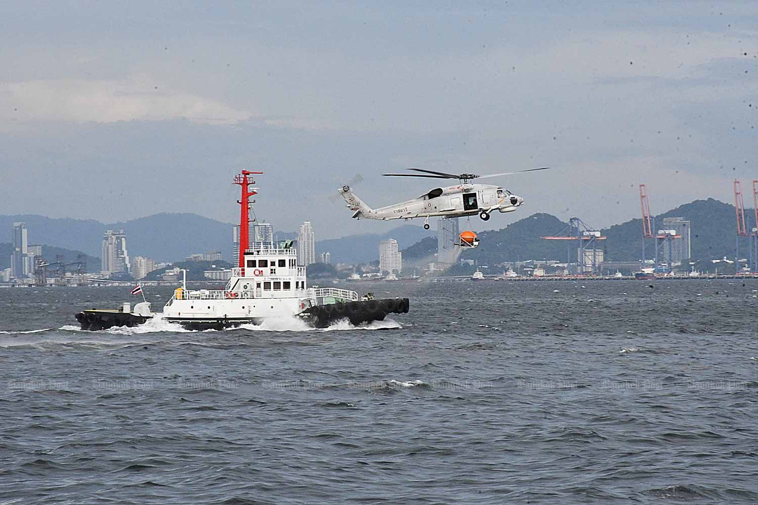 A helicopter sprays dispersants on an oil slick off Sri Racha district of Chon Buri on Tuesday. (Photo: Pongpat Wongyala)