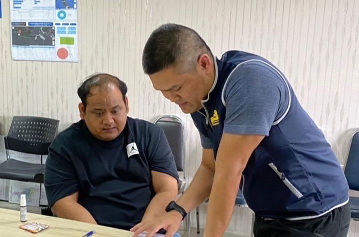 Praween Chankhlai, alias Kamnan Nok, left, undergoes questioning by police from the Crime Suppression Division in Bangkok on Friday. (Police photo)