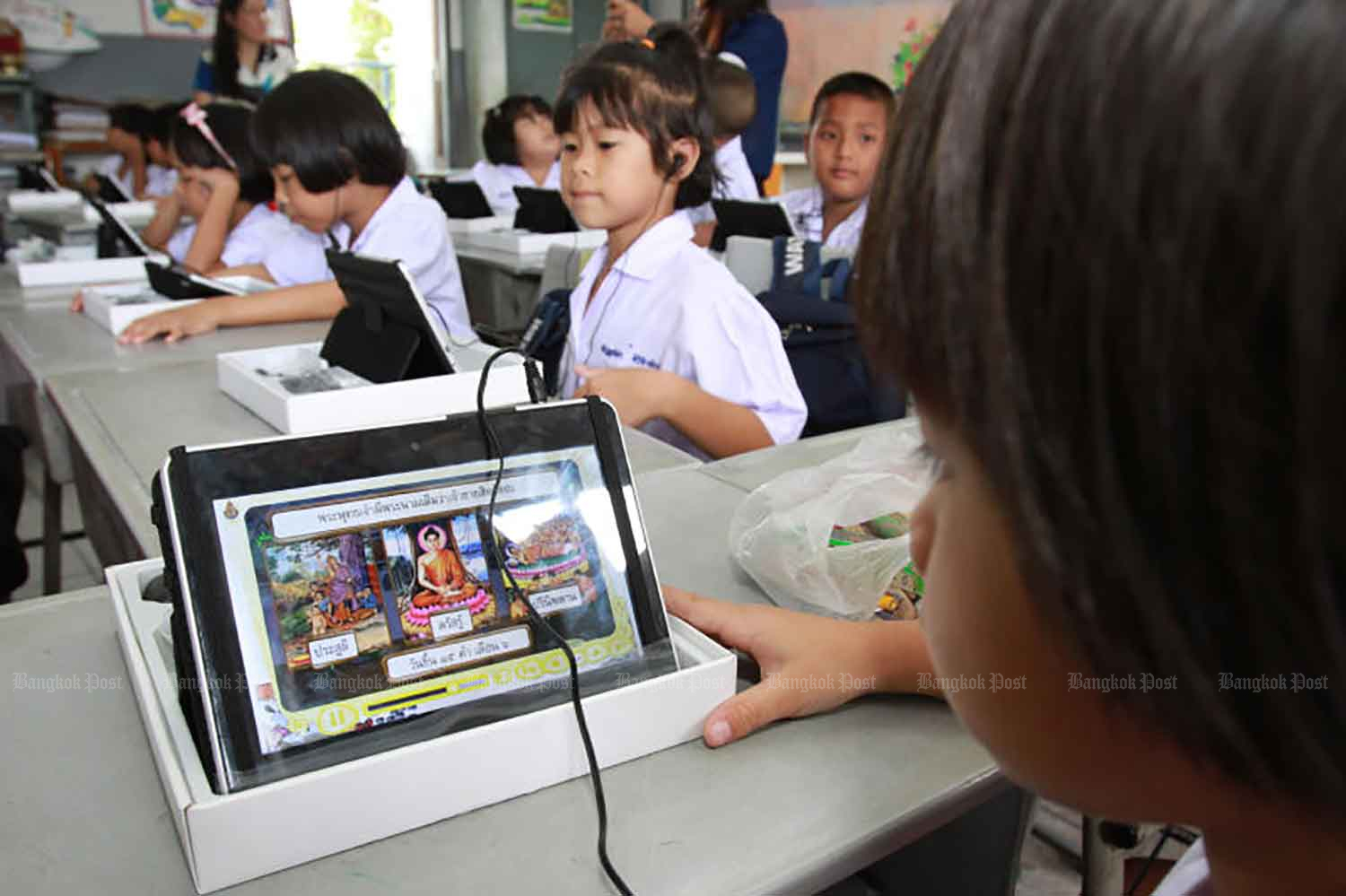 Prathom 1 (Grade 1) students from Don Thong School, in Muang district of Chachoengsao, learn how to use tablet computers provided under an earlier government programme in September 2012. (Bangkok Post File Photo)