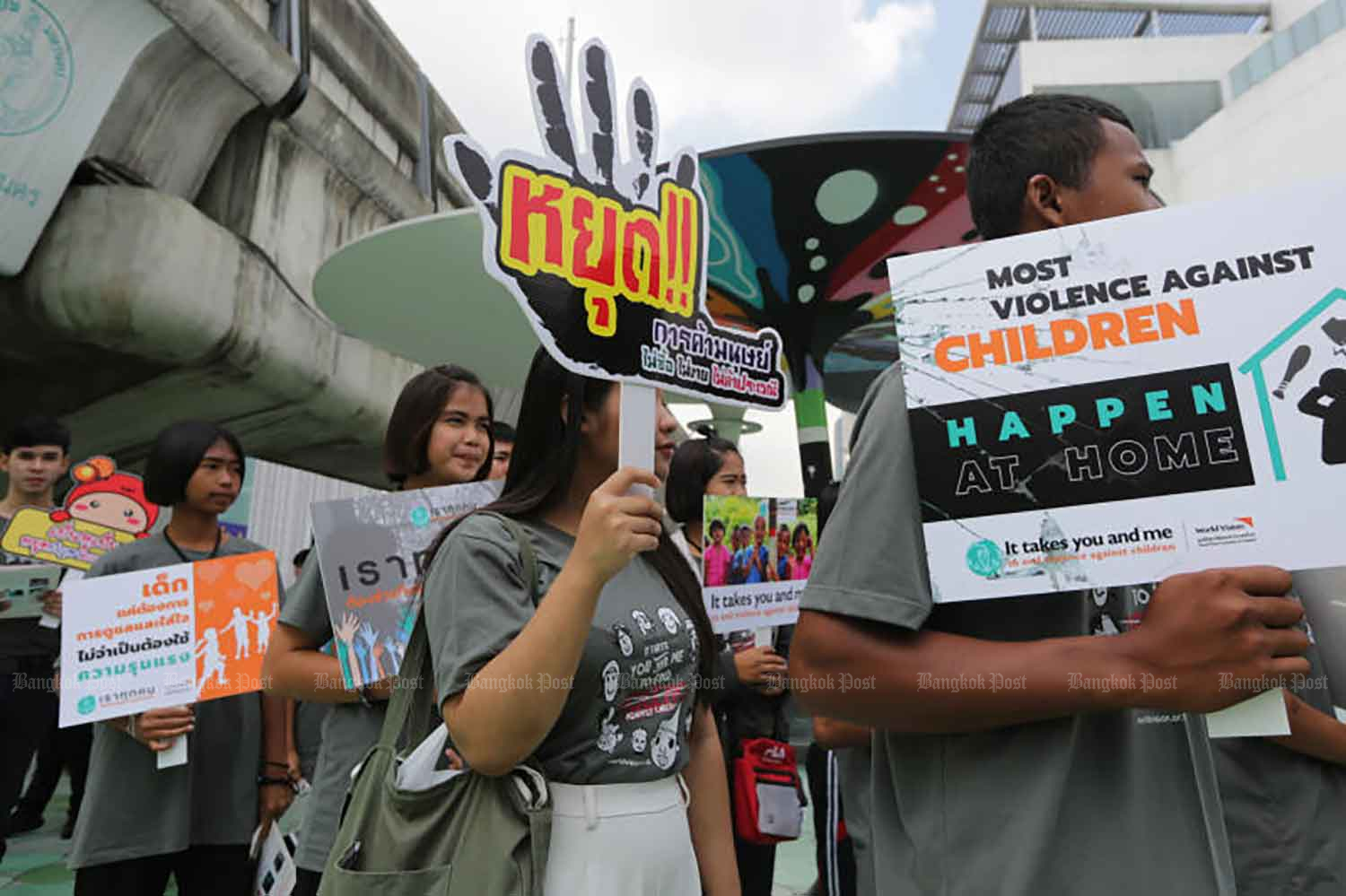 Youngsters take to the skywalk in Siam Square with placards denouncing violence against children. (File photo: Wichan Charoenkiatpakul)