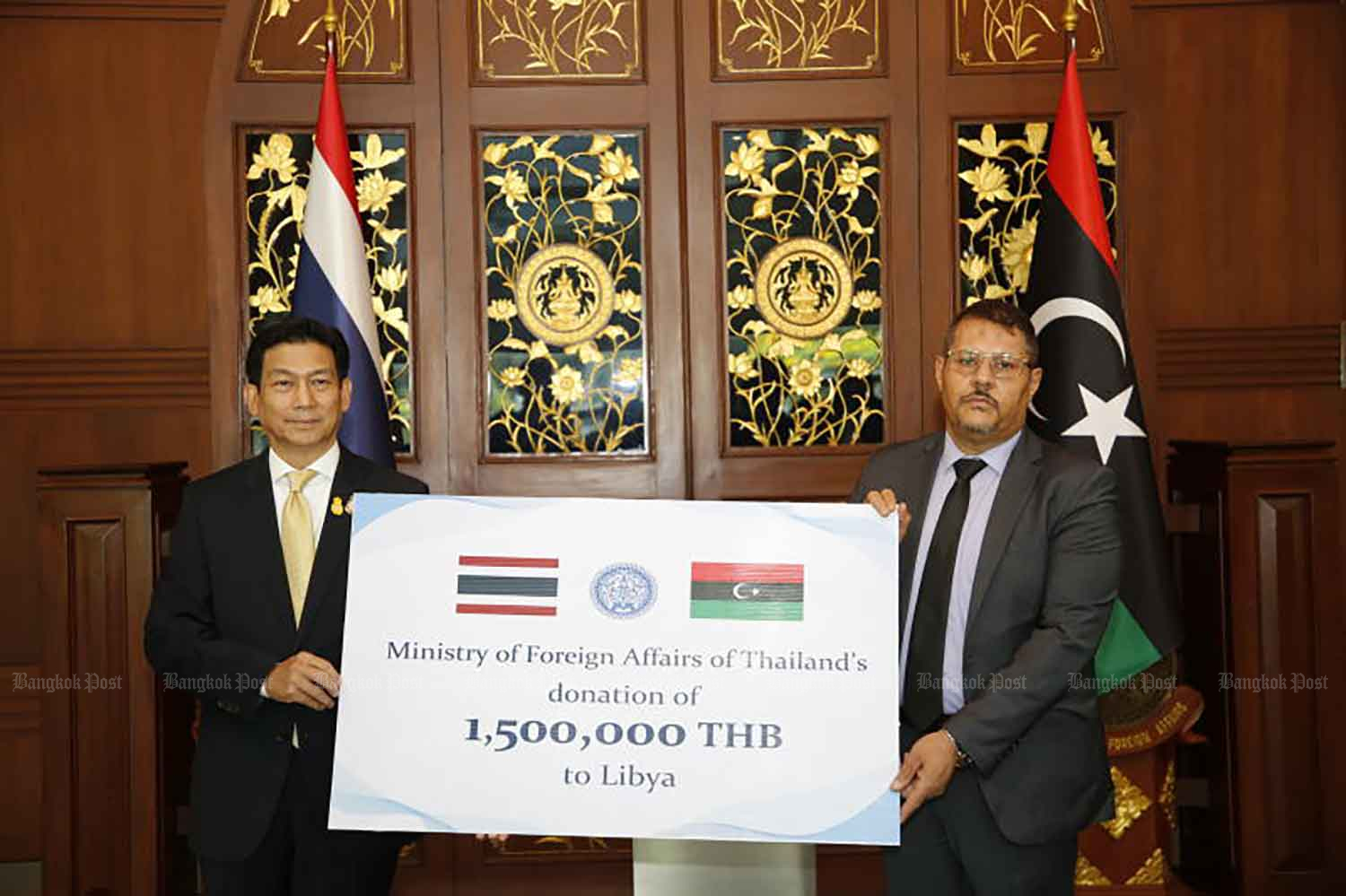 Foreign Minister Parnpree Bahiddha-Nukara, left, is seen at the donation ceremony with Libyan charge d'affaires in Bangkok Ashoor Salem Ashoor Omran at the Ministry of Foreign Affairs on Monday. (Photo: Wichan Charoenkiatpakul)