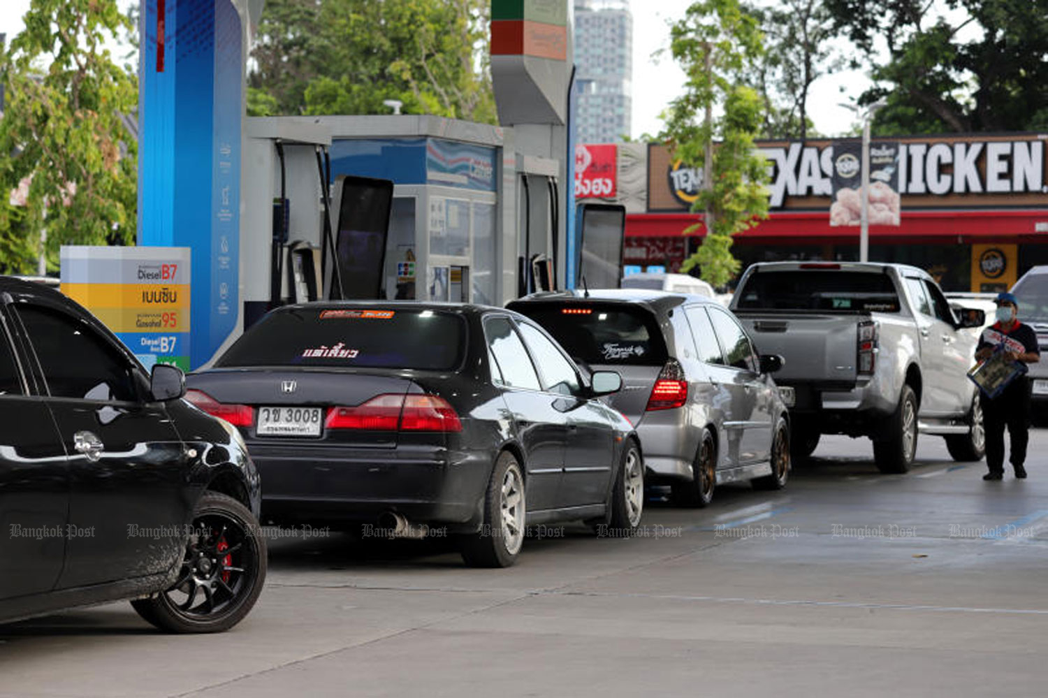 Cars queue at a PTT petrol station in Bangkok. The domestic diesel price is set to fall on Wednesday morning to 29.94 baht a litre from 31.94 baht. (Photo: Chanat Katanyu)