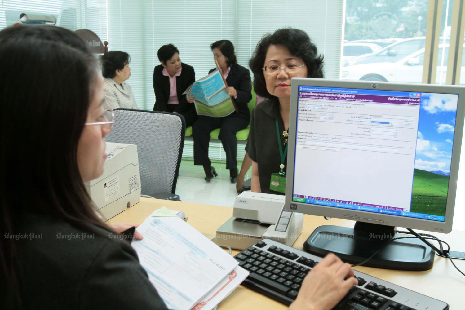 A taxpayer submits personal income tax forms to a Revenue Department official. The department recently amended its notification regarding taxation on specified foreign-sourced income by stipulating that local residents who earn overseas income will be subject to personal income tax (PIT). (Photo: Apichit Jinakul)