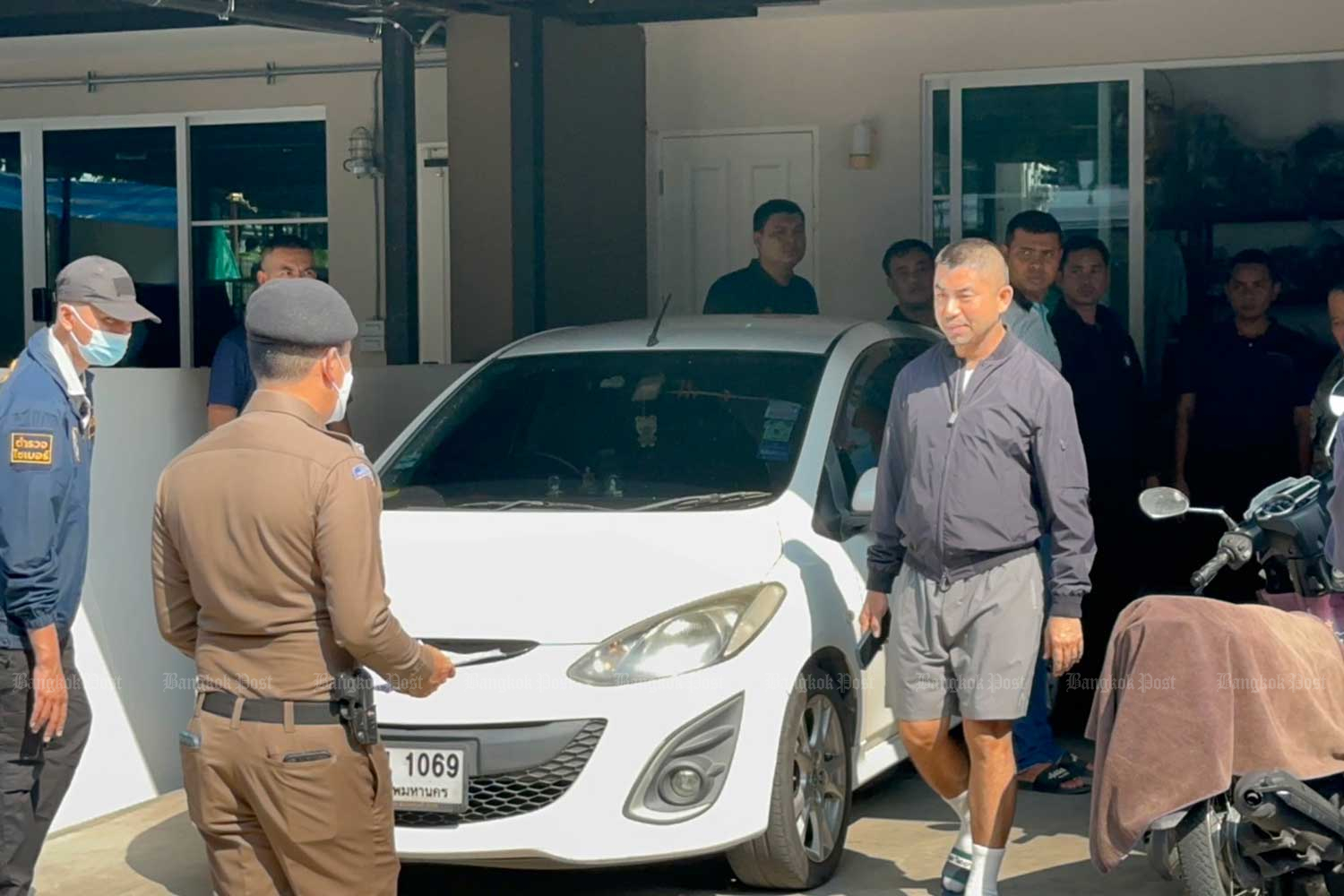 Pol Gen Surachate Hakparn walks towards a police officer during the search at one of his properties on Monday morning. (Photo supplied)