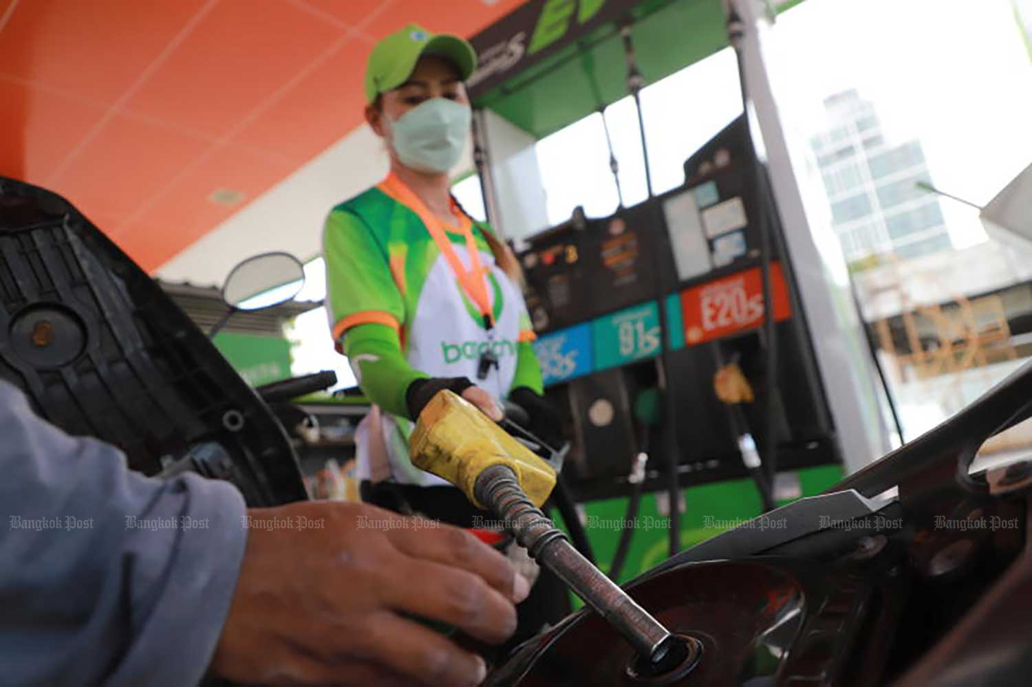 An attendant refuels a motorcycle at a Bangchak petrol station on Sept 20. (Photo: Somchai Poomlard)