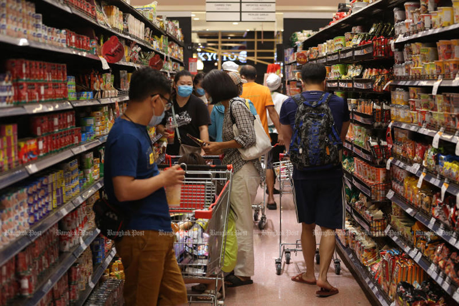 People buy consumer goods at a supermarket in Bangkok. The prices of more than 150,000 products and services will be cut by as much as 87%, effective immediately, until the end of December. (File photo: Varuth Hirunyatheb)