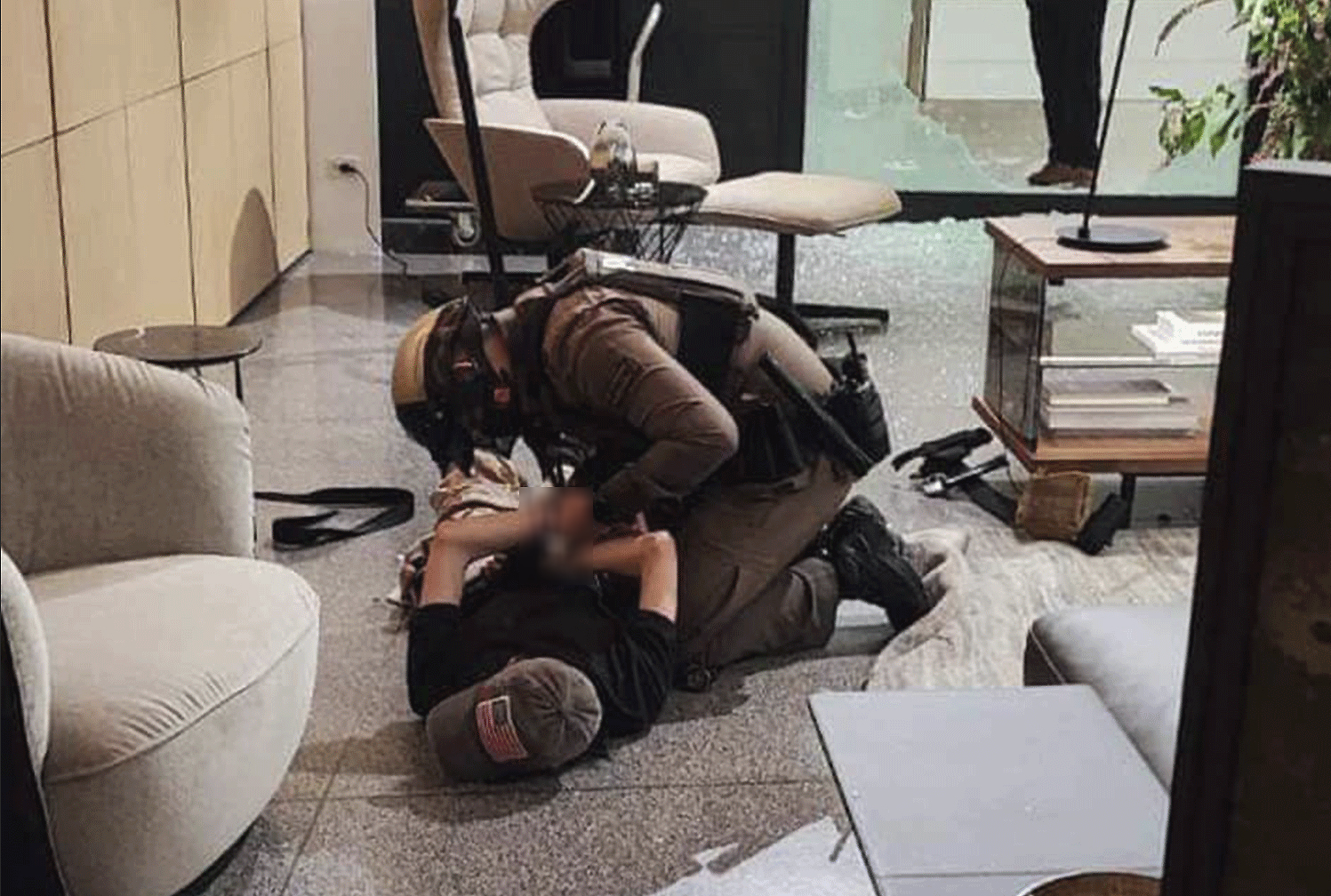 A police officer handcuffs a suspected gunman inside a furniture store on the third floor of Siam Paragon, following a shooting inside the shopping centre on Tuesday afternoon. (Photo: Central Investigation Bureau Facebook)