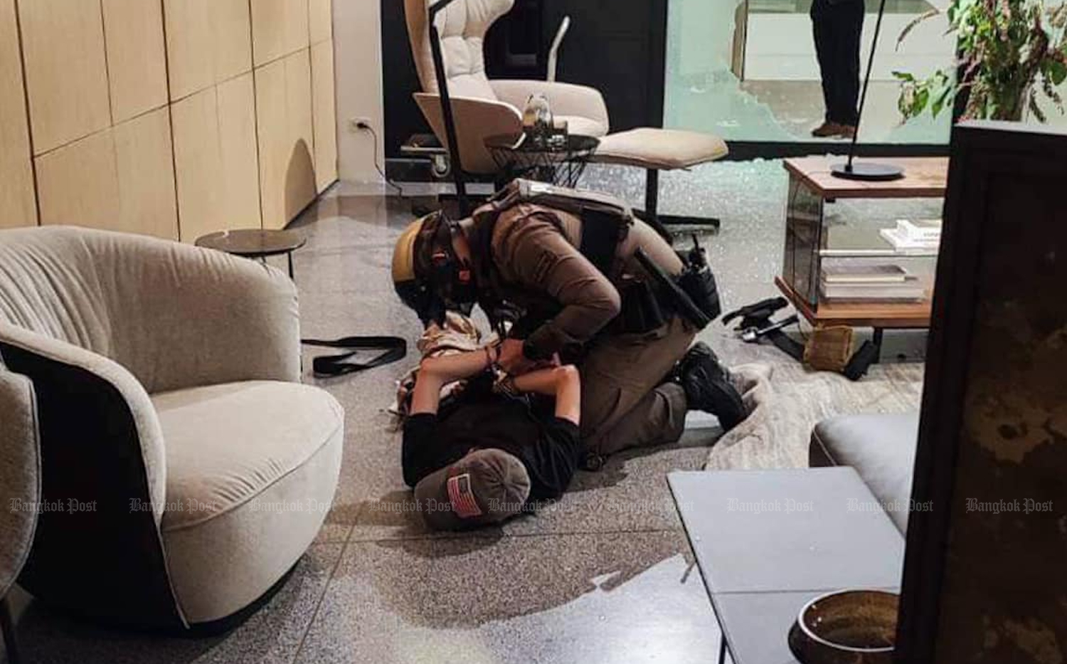 A police officer handcuffs a suspected gunman inside a furniture store on the third floor of Siam Paragon, following a shooting inside the shopping centre on Tuesday afternoon. (Photo: Central Investigation Bureau Facebook)