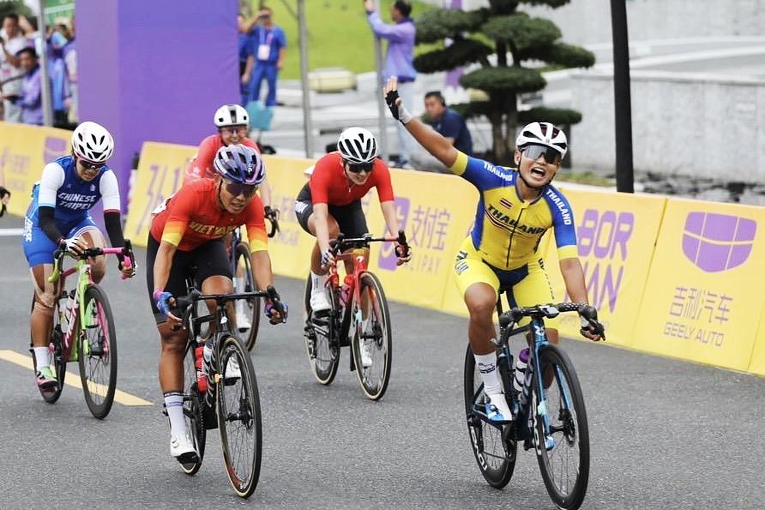 Cyclist Jutatip Maneephan, right, finishes third in the women's road race.