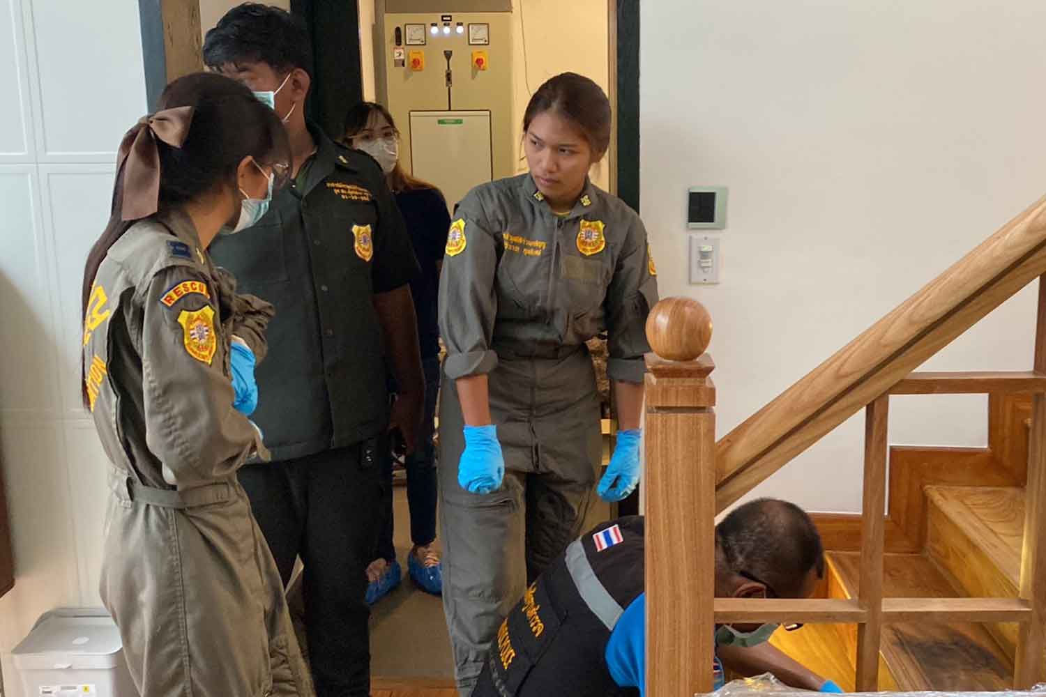 Forensic police collect stains from the staircase in a house in Chatuchak district where a former Thai ambassador to Denmark was found dead in a toilet on Sunday morning. (Photo supplied)