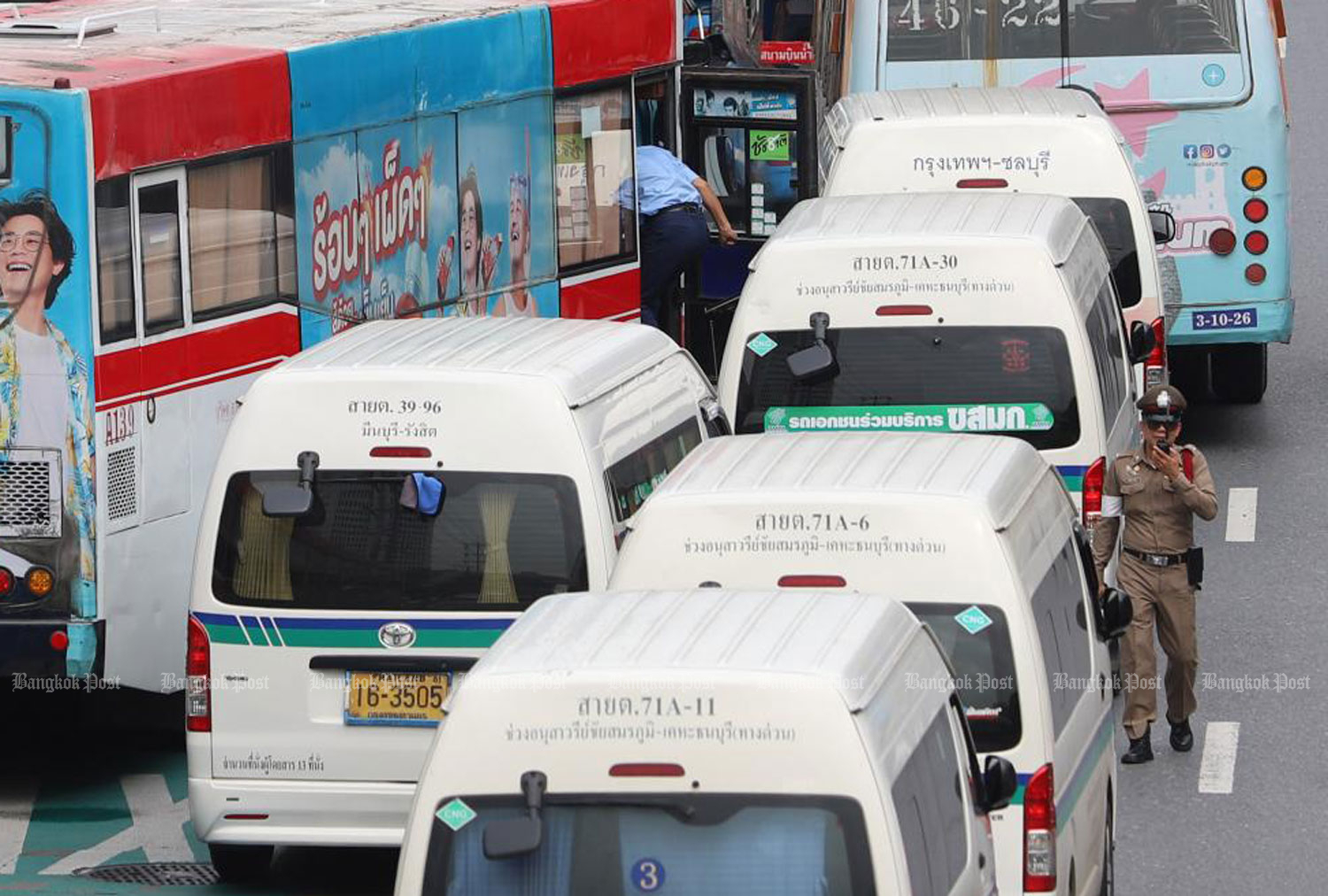 Bumper to bumper: Public vans wait to pick up passengers at a bus stop.  (Photo: Pattarapong Chatpattarasill)