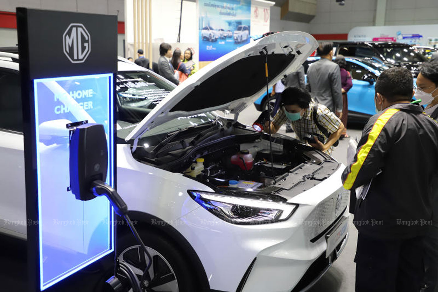 A woman takes a close look at the engine of an electric car at the FAST Auto Show Thailand at the Bangkok International Trade and Exhibition Center in July. (Photo: Wichan Charoenkiatpakul)