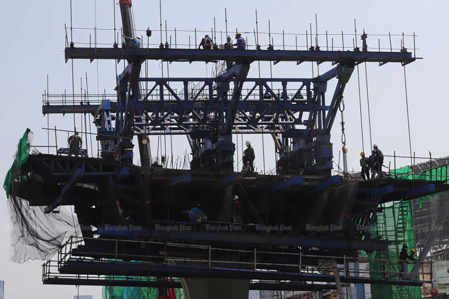 Workers are seen assembling an overpass at the Na Ranong intersection in 2022. Most construction workers receive daily wage payments at the minimum rate. (Photo: Pornprom Satrabhaya)