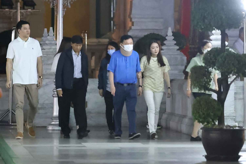 Former prime minister Thaksin Shinawatra, in blue shirt and face mask, visits the City Pillar Shrine on early Thursday morning. He was accompanied by his daughter Paetongtarn Shinawatra, right, and her husband Pitaka Suksawat, left. (Photo supplied)
