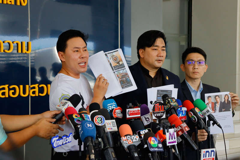 Lawyer Sittra Biabungkerd, left, and Tankhun Jitt-itsara, centre, show pictures of luxury watches and celebrities who are dubbed "bosses" of The iCon Group, a well-known online business promoter accused of running a pyramid scheme, at the Central Investigation Bureau complaint centre on Friday. (Photo supplied/Wassayos Ngamkham)
