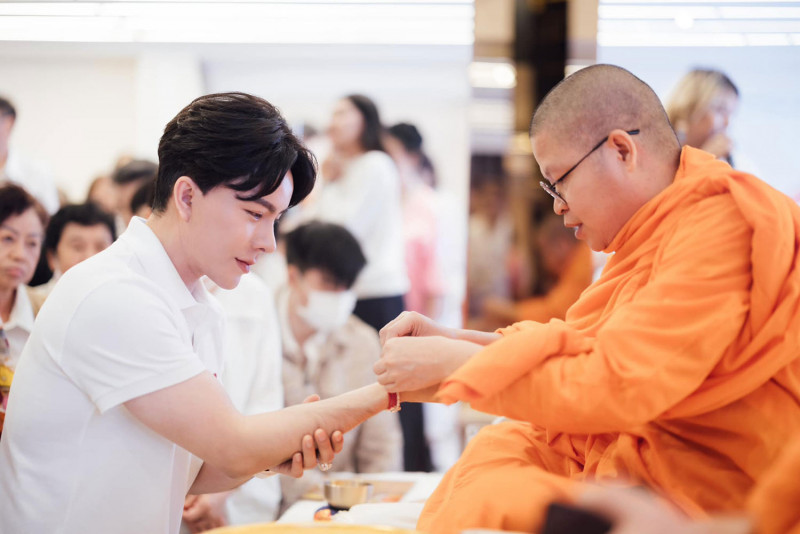 V. Vajiramedhi ties holy threads around the wrist of The iCon Group CEO Warathaphon Waratyaworrakul during the sermon he was invited to give on March 12. (Photo: The iCon Group Facebook account)