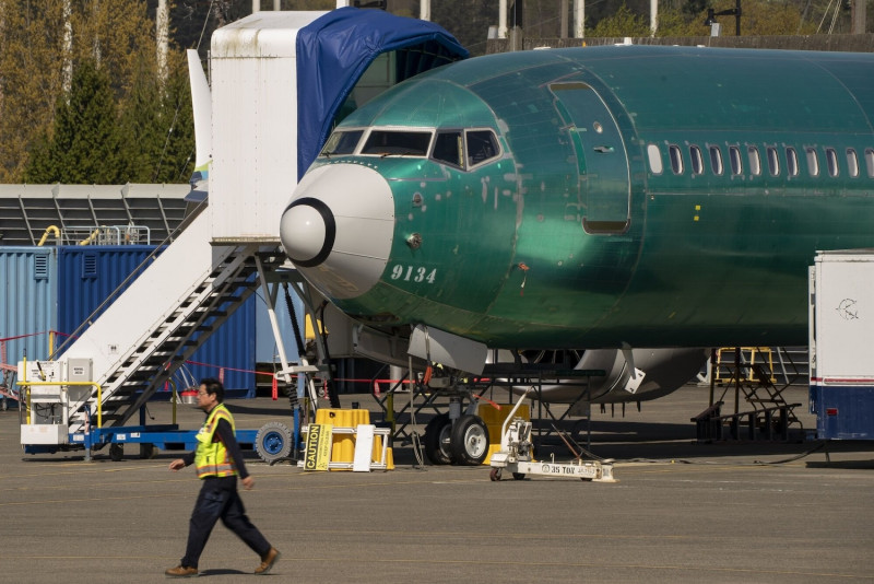 A worker walks past a Boeing 737 Max passenger jet at the company’s manufacturing facility in Renton, Washington, near Seattle, on April 15. (Photo: Bloomberg)