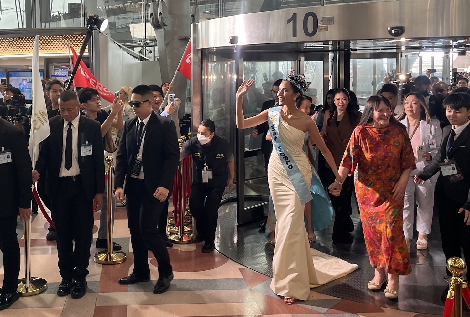 Miss World 2025 Suchata “Opal” Chuangsri, accompanied by Julia Morley, chairperson of the Miss World Organisation, waves to supporters on her arrival at Suvarnabhumi airport on Saturday. (Photo: Sooksodsai Sooksomchitra)