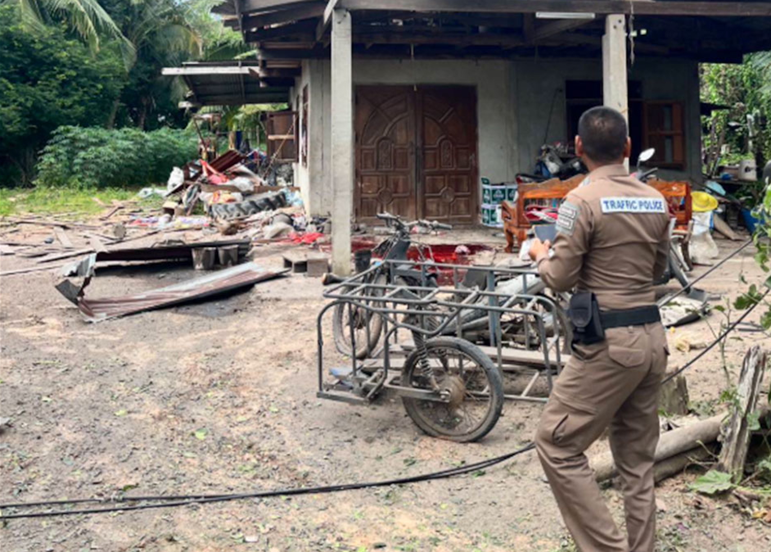 A police officer inspects a house in Kap Choeng district of Surin after rockets fired by Cambodian forces struck civilian targets, leaving three Thai residents injured on Thursday morning. (Photo: Royal Thai Army public relations)