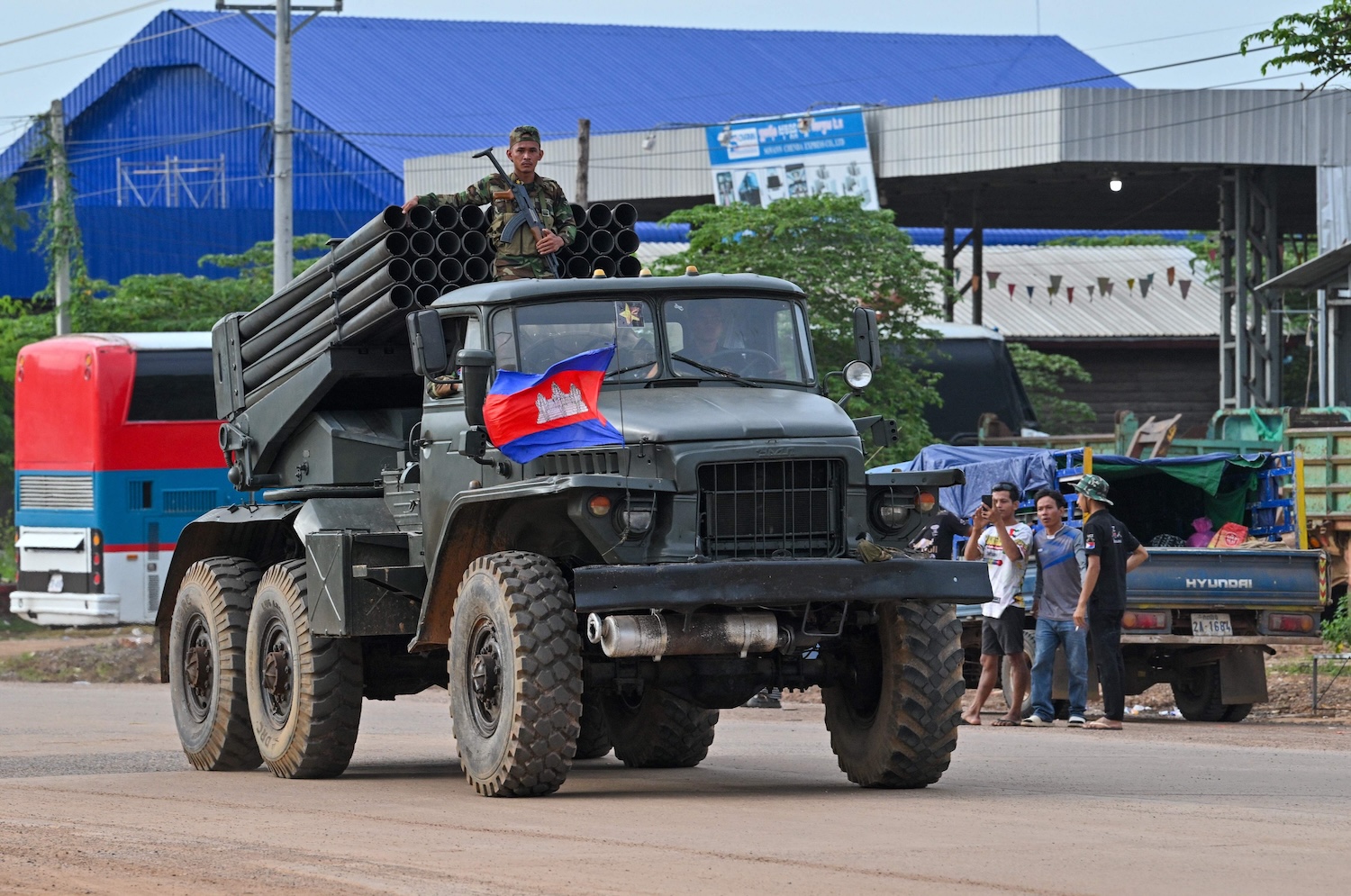 A Cambodian soldier stands on a truck carrying a Russian-made BM-21 rocket launcher travelling along a street in Oddar Meanchey province on July 25. (Photo: AFP)