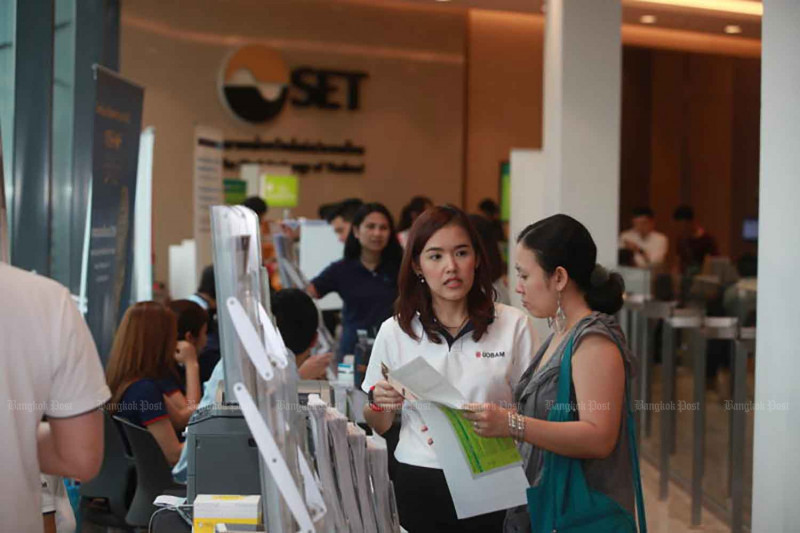 Workers from an asset management firm provide details about a mutual fund to customers at a mutual fund fair in Bangkok in 2016. Bangkok Post file photo
